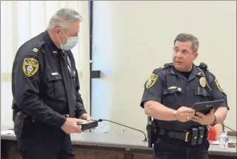  ?? Jeremy stewart ?? Cedartown Police Chief Jamie Newsome (right) reads a plaque featuring the badge of Capt. Henry Runyan while honoring the retiring officer during the meeting of the Cedartown City Commission on July 13.
