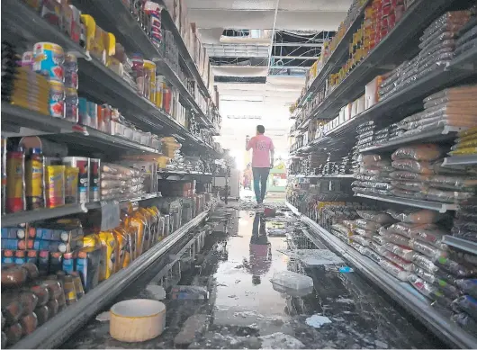  ?? BRIAN KRISTA/CAPITAL GAZETTE ?? Walter Vasquez, owner of Annapolis Internatio­nal Market, surveys the storm damage to his store on West Street in Annapolis on Thursday.