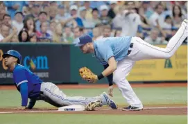  ?? PHELAN M. EBENHACK/THE ASSOCIATED PRESS ?? The Toronto Blue Jays’ Anthony Gose, left, safely advances to third base on a fly-out by Jose Bautista as Tampa Bay Rays third baseman Evan Longoria is late with the tag.