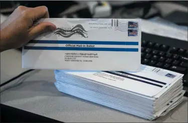  ?? MATT ROURKE — ASSOCIATED PRESS FILE ?? In a May 28, 2020 file photo, Dave Turnier processes mail-in ballots at the Chester County Voter Services office in West Chester, Pa., prior to a primary election.