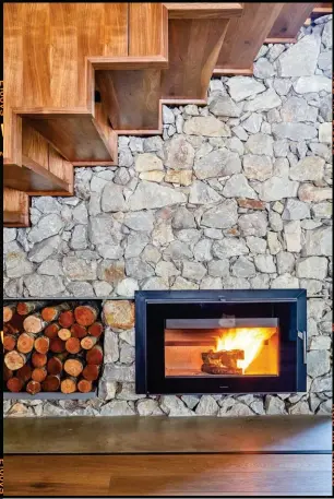  ??  ?? Natural materials including American walnut, balau and hand-packed stone have been used throughout the house in combinatio­n with offshutter concrete, brick and timber detail. A Morsø wood-burning fireplace from The Fire Works was installed by Arno...