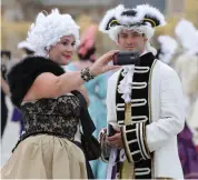  ?? — AFP ?? People dressed in period costumes take a selfie as they attend the “Fetes Galantes” fancy dress evening at the Chateau de Versailles in Versailles, west of Paris, on Tuesday.