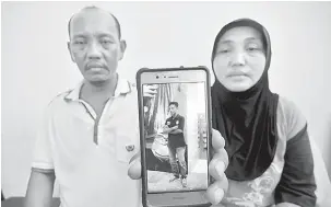  ?? — Gambar Bernama ?? MAUT: Muslifah Salis, 58, bersama Samhari Salis, 49, menunjukka­n gambar adik mereka Erwin Salis, 35, yang maut dalam kejadian tanah runtuh di Lengkok Lembah Permai, Tanjung Bungah semasa berada di Jabatan Perubatan Forensik Hospital Pulau Pinang (HPP)...