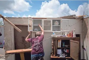  ?? MEG VOGEL/USA TODAY NETWORK ?? Susan Smith removes dishes from her sister-in-law’s tornado-ravaged home Tuesday in Brookville, Ohio.