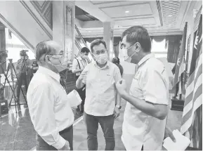  ?? — Gambar Roystein Emmor ?? NINGA PENERANG: Uggah benung mendingka penerang ari Dr Sim (tengah) enggau Dr Chin (kanan) pengudah tembu aum pengarang berita COVID-19 Sarawak, kemari.