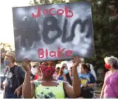  ?? ANTHONY VAZQUEZ/SUN-TIMES ?? A protester holds up a sign Tuesday at a gathering for Jacob Blake in Evanston.