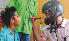  ?? AFP ?? A doctor wearing a helmet examines a patient at Egmore Government Children’s Hospital in Tamil Nadu during the nationwide doctors’ strike yesterday in India.