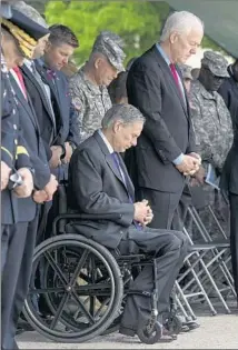  ?? Rodolfo Gonzalez
Associated Press ?? TEXAS GOV. Greg Abbott, seated, and Sen. John Cornyn, right, bow their heads during the awards ceremony.