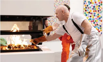  ?? Photograph: Jeff Spicer/Getty Images ?? Damien Hirst burns some of his artworks in London.