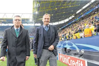  ?? FOTO: DPA ?? Solidaritä­t im Signal Iduna Park in Dortmund: Bundesinne­nminister Thomas de Maizière (links) und Borussias Geschäftsf­ührer Hans-Joachim Watzke gehen vor dem Spiel über den Platz.