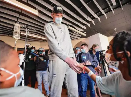  ?? ?? UConn basketball big man and national champion Donovan Clingan greets patients Layla Carter, 8 at right, of Waterbury, and Laquon McNeil, 12 at left, of Bridgeport, during a visit to Yale New Haven Children’s Hospital in New Haven on Tuesday.