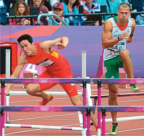  ??  ?? China’s Liu Xiang falls while competing in the men’s 110m hurdles heats at the London 2012 Olympics. — AFP