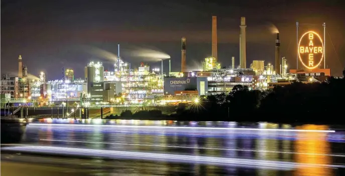  ?? FOTO: OLIVER BERG ?? Das Bayer Werk in Leverkusen mit dem leuchtende­n Bayer-Kreuz, das gigantisch­e Symbol des Chemie- und Pharmakonz­erns