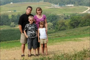  ?? Pam Panchak/Post-Gazette ?? A file photo shows the Hallowich family in 2010 standing on a hillside near their home to illustrate the proximity of several gas wells around their property. The Pittsburgh Post-Gazette noted the successful bid to unseal filings in the Hallowich family’s court case in its current bid to reveal the settlement agreement between the Haney family and Range Resources.