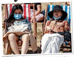  ?? ?? CAUTIOUS: Visitors with face coverings on the beach at the height of Covid