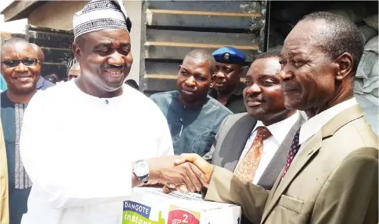  ??  ?? Benue State Governor Gabriel Suswam receiving a carton of Dangote noodles from Engr. Joseph Makoju of the Dangote Group as part of the 12 truck load of items donated by the Dangote Group to victims of insurgency in the state. ..weekend