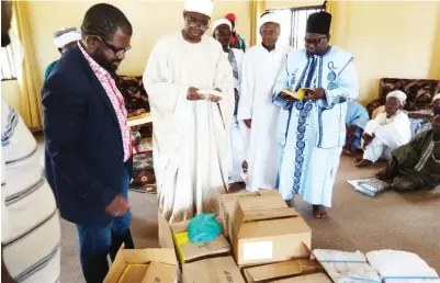  ??  ?? Executive Director CURE, Sylvester Uhaa (l) and the Emir of Karshi, Alhaji Ismaila Muhammed (c) during the NGO's donation of books to three schools in Karshi, FCT recently