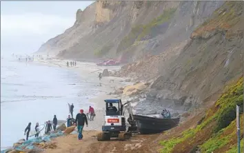  ?? Nelvin C. Cepeda San Diego Union-Tribune ?? BEACHGOERS EXAMINE one of two smuggling boats that overturned along the San Diego County coast last week. At least eight migrants from Mexico died, authoritie­s said, and many others remained missing.