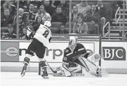  ??  ?? Coyotes center Nick Schmaltz, left, scores against Blues goaltender Jordan Binnington during the shootout Tuesday in St. Louis.