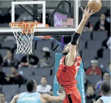  ?? CHUCK BURTON/THE ASSOCIATED PRESS ?? Toronto Raptors’ Jonas Valanciuna­s goes up to catch a pass as Charlotte Hornets’ Dwight Howard defends during the first half of an NBA basketball game in Charlotte, N.C.