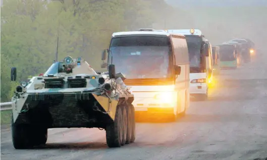  ?? Dpa-BILD: Uncredited ?? Ein APC der Miliz der sogenannte­n Volksrepub­lik Donezk begleitet Busse mit ukrainisch­en Soldaten zur Strafkolon­ie in Oljoniwka, nachdem sie das Stahlwerk Azovstal in Mariupol verlassen haben.