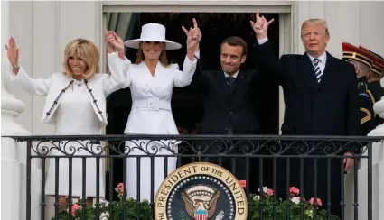  ?? — AP ?? President Donald Trump, first lady Melania Trump, French President Emmanuel Macron and his wife Brigitte Macron wave from the Truman Balcony during a state arrival ceremony on the South Lawn of the White House in Washington on Tuesday.