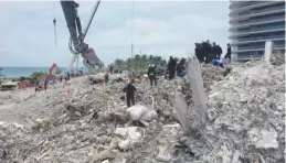  ?? (Courtesy of Miami-Dade Fire Rescue Department/Reuters) ?? SEARCH-AND-RESCUE personnel search debris of the collapsed Champlain Towers South condominiu­m in Surfside, Florida, earlier this week.