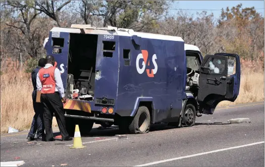  ?? PICTURE: MASI LOSI ?? Police look at the back of a cash-in-transit van that was ambushed during a heist in Moloto Road, which connects Gauteng, Mpumalanga and Limpopo.