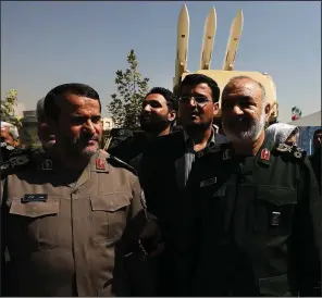  ?? AP/VAHID SALEMI ?? Gen. Hossein Salami (right), chief commander of Iran’s Revolution­ary Guard, attends a Tehran ceremony on Saturday displaying the anti-missile system used to intercept a U.S. drone in June in the Strait of Hormuz. Salami declared his forces ready for combat, saying, “If anyone crosses our borders, we will hit them.”