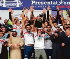  ?? AFP ?? Zamalek’s players celebrate their Egyptian Super Cup victory against Al Ahly with team management and supporters.