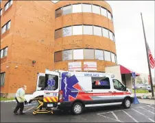  ?? Christian Abraham / Hearst Connecticu­t Media ?? An American Medical Response crew arrives with a COVID-19 patient at Northbridg­e Health Care Center on Main Street in Bridgeport on Apr. 21.