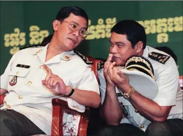  ?? ROB ELLIOTT/AFP ?? Prime Minister Hun Sen (left) speaks to General Ke Kim Yan during a ceremony at the Ministry of Defence in 1999.