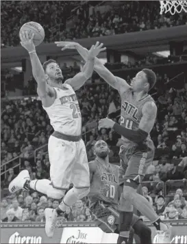  ??  ?? New York Knicks guard Derrick Rose goes to the basket against Atlanta Hawks forward Kent Bazemore and guard Tim Hardaway Jr.