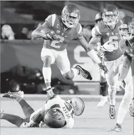  ?? Luis Sinco Los Angeles Times ?? ADOREE’ JACKSON, who set a USC record for kick return yardage during the first half, hurdles California’s Jordan Veasy on a punt return at the Coliseum.