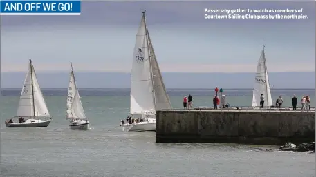  ??  ?? Passers-by gather to watch as members of Courtown Sailing Club pass by the north pier.