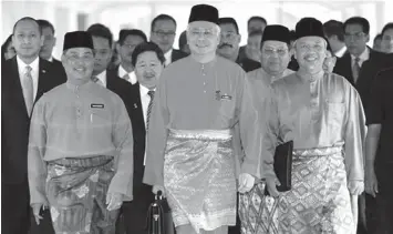  ?? ASSOCIATED PRESS ?? Malaysian Prime Minister and Finance Minister Najib Razak (center) accompanie­d by other ministers, arrives to unveil the Malaysia's 2011 budget at the Parliament house in Kuala Lumpur, Malaysia.