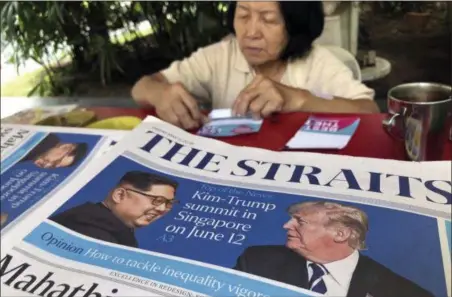  ?? WONG MAYE-E — THE ASSOCIATED PRESS FILE ?? A news vendor counts her money near a stack of newspapers with a photo of U.S. President Donald Trump, right, and North Korea’s leader Kim Jong Un on its front page in Singapore. U.S. Weeks from his North Korea summit, President Donald Trump is staring...