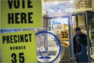  ?? JAKE MAY — THE FLINT JOURNAL — MLIVE.COM VIA ASSOCIATED PRESS ?? In this Tuesday, Nov. 8, 2016 file photo, a man walks out of City Hall after voting in downtown Flint, Mich.