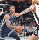  ?? BRANDON DILL/AP ?? Grizzlies guard Ja Morant drives against Spurs forward Jeremy Sochan during the first half of an NBA basketball game on Jan. 11, in Memphis.