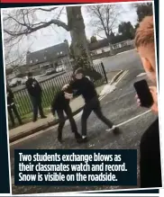  ??  ?? Two students exchange blows as their classmates watch and record. Snow is visible on the roadside.