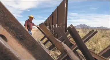  ?? Brian van der Brug / Tribune News Service ?? Gary Thrasher looks over a Normandy vehicle barrier near the San Pedro River bordering his friend and fellow rancher John Ladd’s property in Cochise County, Ariz.