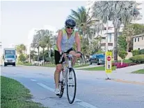  ?? JOHN MCCALL/SUN SENTINEL ?? A bicyclist rides down State Road A1A on Tuesday in Highland Beach. City residents will soon be voting on items, which include a sidewalk improvemen­ts project on the popular walking route along SR A1A.