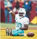  ?? ROB CARR/GETTY ?? Dolphins receiver Tyreek Hill celebrates his touchdown by starting a roller-coaster skit with teammates.