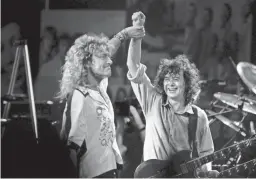  ?? DON EMMERT/AFP/GETTY IMAGES ?? Robert Plant, left, holds hands raised high with Jimmy Page during a Led Zeppelin reunion performanc­e at Madison Square Garden in New-York on May 14, 1988.