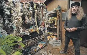  ??  ?? PETERS saves some of the debris he collects from the creek, including tangled netting and rope, barnacle-covered rubber balls, cellphone cases and chip wrappers.