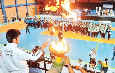  ?? FOTOS: JOSÉ ROCHA ?? Ricardo Pucho (izq.), estudiante del CEE Jesús Maestro de Tiquipaya, enciende la llama olímpica, ayer.