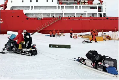  ??  ?? The China Arctic scientific investigat­ion team transports equipment and supplies via a snowmobile at their station.