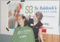  ??  ?? Renee Wah of McQueen, Va., laughs at a joke while getting her head shaved by Sam Baker, manager at Sports Clips in La Plata, during the “Going Bald for a Cause Southern Maryland” fundraiser in support of childhood cancer research Saturday.