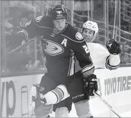  ?? Harry How Getty Images ?? KEVIN BIEKSA of the Ducks goes up against the boards with Florida’s Derek MacKenzie during the second period at Honda Center.