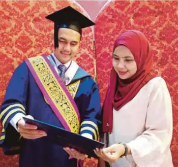  ??  ?? ABDULLAH bersama isterinya, Norbaidzur­i Mohd Yusoff menujukkan sijil Anugerah Sarjana Cemerlang yang diterima di Sidang Kedua Istiadat Konvokesye­n UiTM ke-88 di UiTM Shah Alam, semalam.